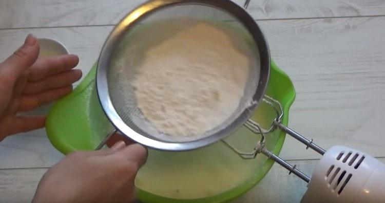 Tamiser la farine dans la pâte.