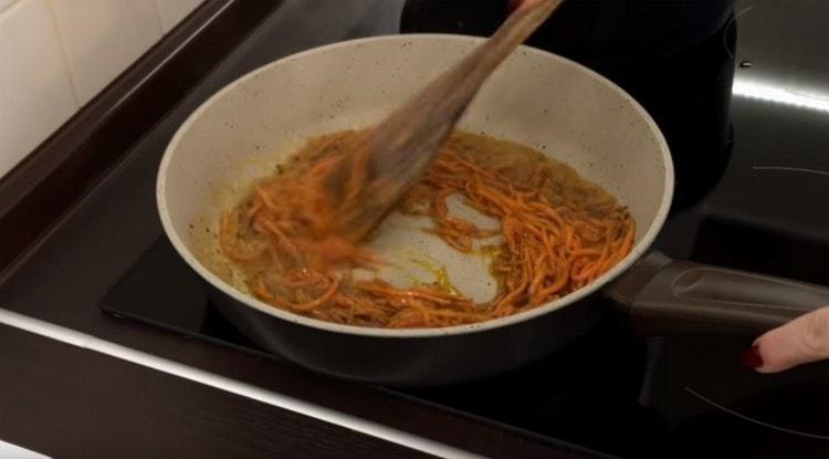 Nous répandons des carottes à la coréenne dans de l'huile aux épices.