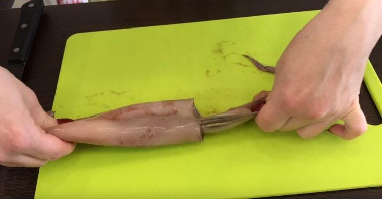 Carefully separate the squid tentacles from the carcass.