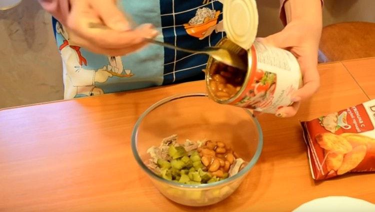 Dans un bol, mélanger les morceaux de boeuf, les haricots, les cornichons tranchés.