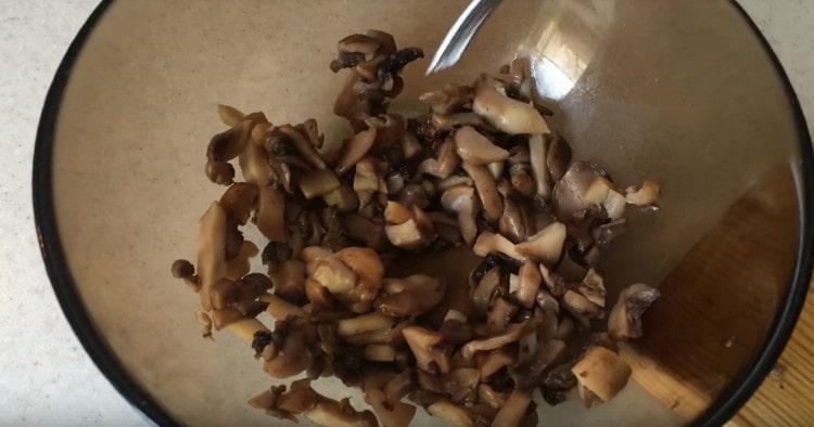 Couper les champignons frits en morceaux.