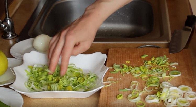 Ikalat ang leek gamit ang unang layer ng salad sa isang malapad na pinggan.