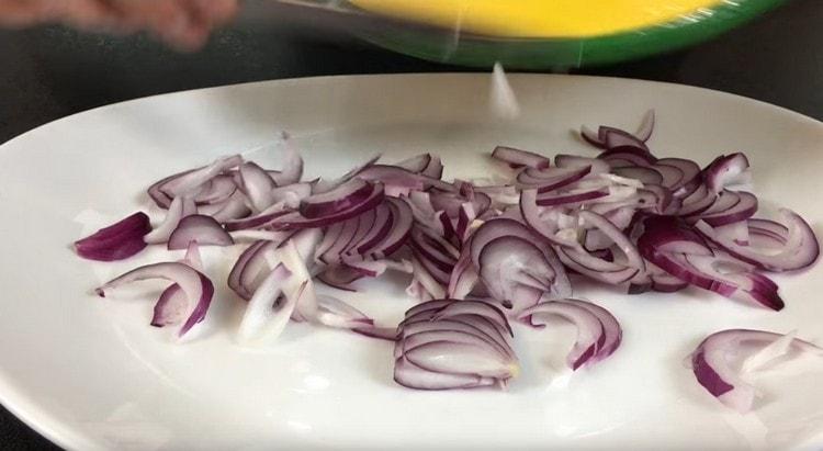 Cortar la cebolla en medio aros y ponerla en el plato.