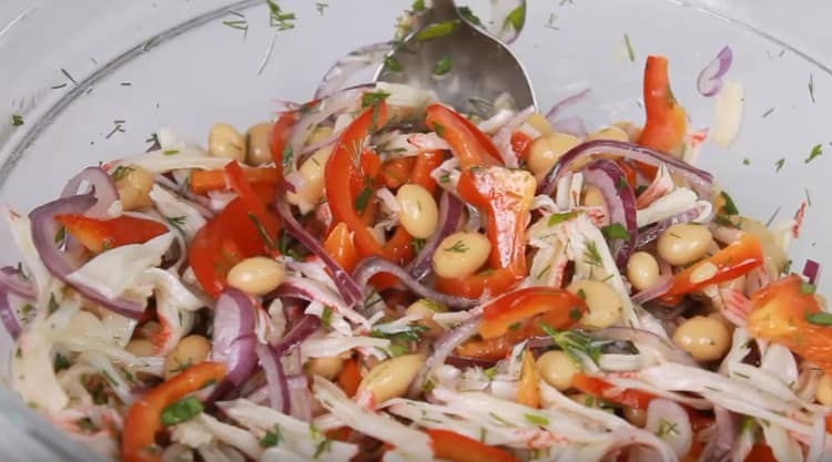 La ensalada fragante con frijoles y palitos de cangrejo está lista.