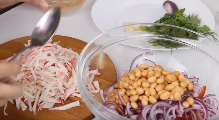 In a bowl with already prepared components, spread the canned beans.