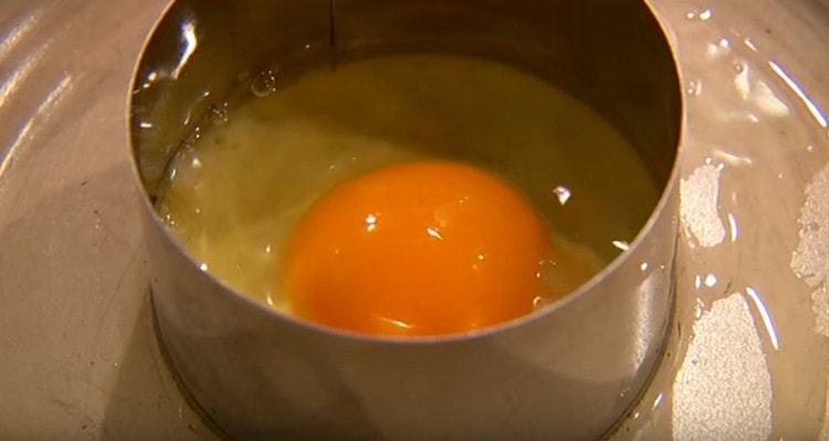 Fry an egg in another pan in a pastry ring.