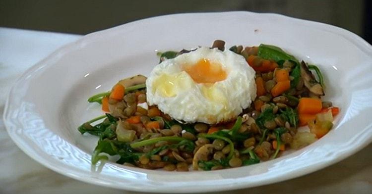 Pon la ensalada con lentejas en un plato para servir y decora con un huevo encima.