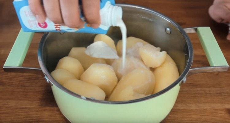 Add the butter and cream to the cooked potatoes.