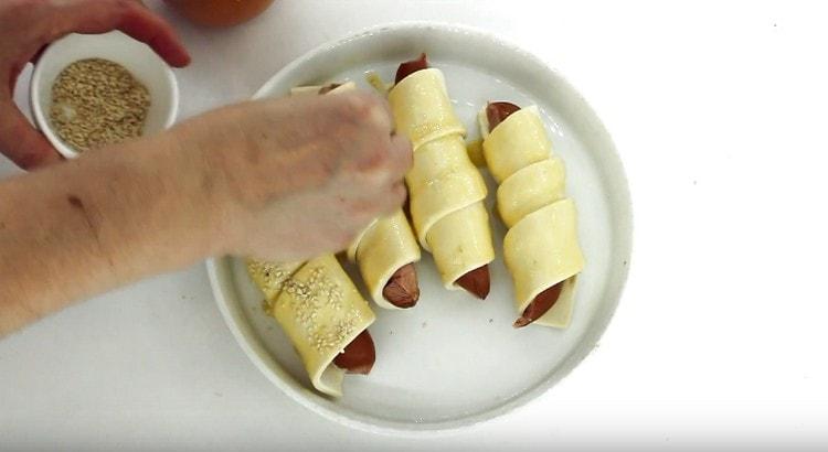 Sprinkle sausages with sesame seeds and put in the oven.