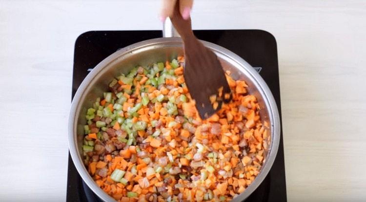 Dodajte mrkvu, celer i pirjajte dok povrće ne postane mekano.