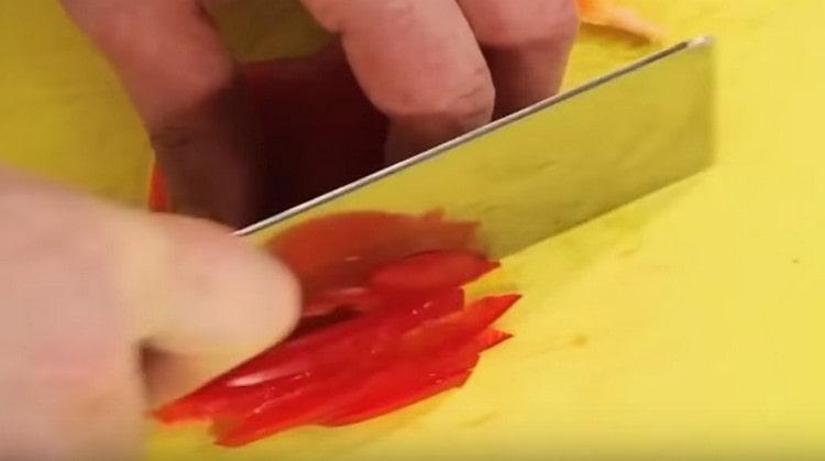 Les pailles coupent le poivron rouge.