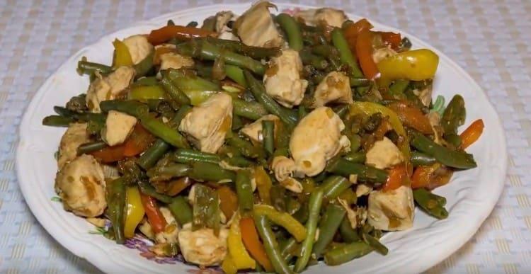 A warm salad of string beans and chicken is ready to serve.