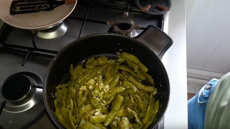 Ajouter l'ail haché aux haricots dans une casserole.