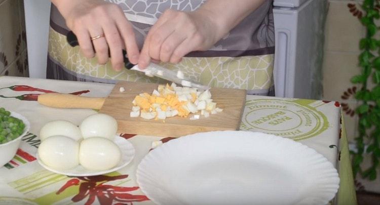 Dice boiled chicken eggs.