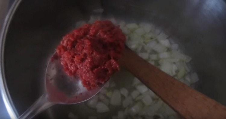 Agregue la pasta de tomate a la cebolla en la sartén.