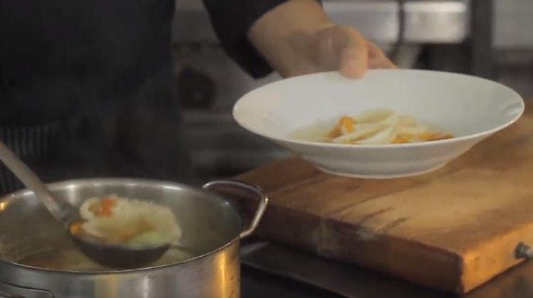 Nous répandons la soupe de calmar dans les assiettes.