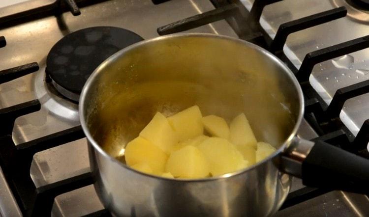 Nous vidons l'eau des pommes de terre bouillies jusqu'à ce qu'elles soient cuites.