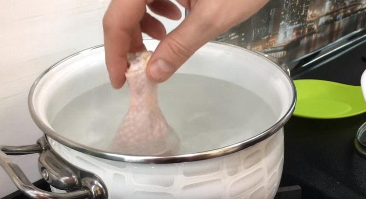 Étendre les cuisses de poulet dans de l'eau bouillante.