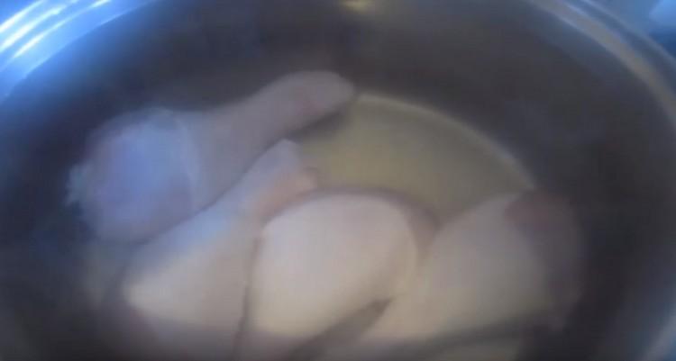 We spread the chicken drumsticks in a pan, bring to a boil, and then drain the water.