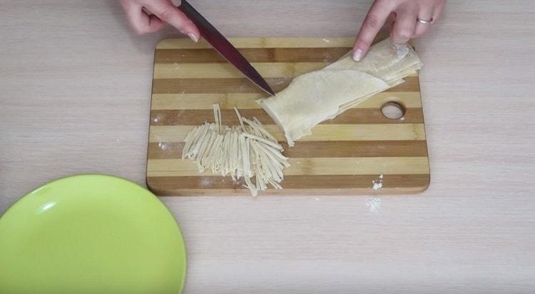 Plier les bandes de pâte les unes sur les autres et les couper en nouilles.