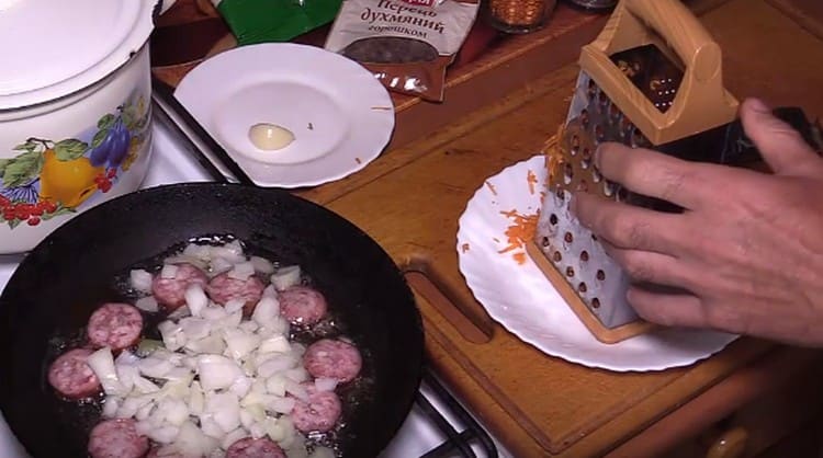 Agregue la cebolla a la salchicha en la sartén.