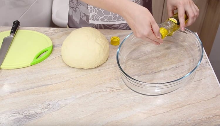 Kneading the dough, grease the vegetable oil in a capacious form.