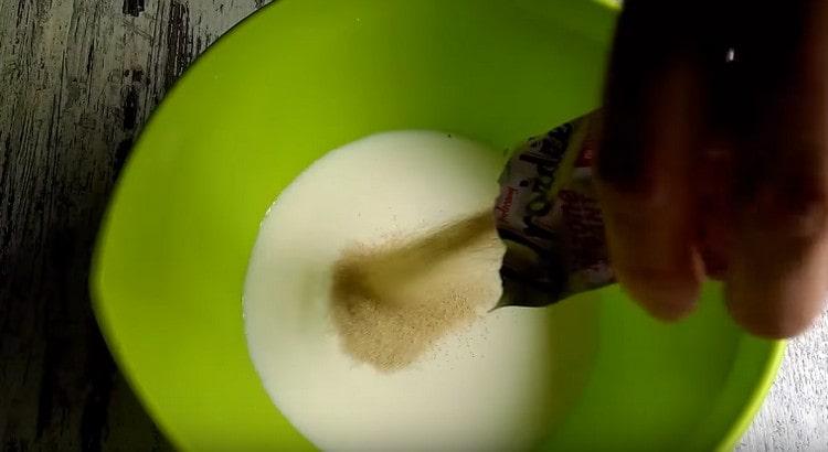 Agregue azúcar y levadura seca a la leche tibia.