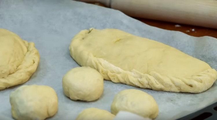 We start the dough with any filling and put the products on a baking sheet.