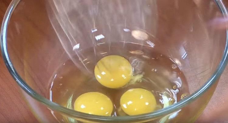 Por separado, batir los huevos con un batidor.