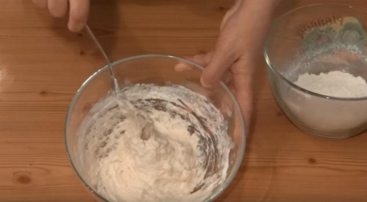 Stir the dough, gradually add the flour.