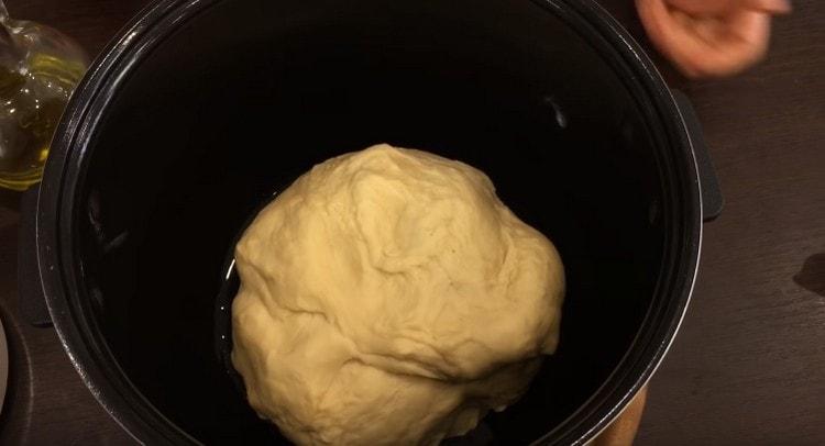 Nous passons la pâte dans le bol multicuiseur, graissé avec de l’huile végétale, et laissons reposer.