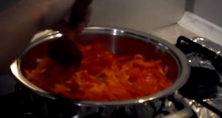 Guisar cebollas, pimientos y zanahorias en una sartén.