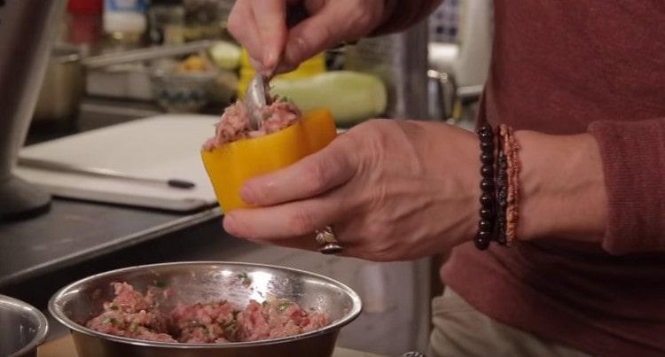 stuffing peppers with minced meat.