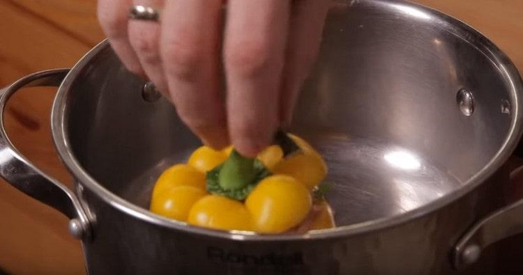 We spread the peppers in a pan, cover them with hats.