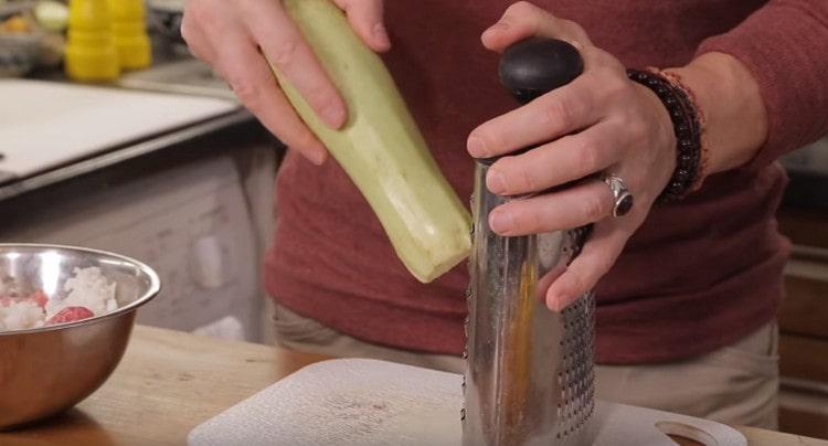 En un rallador, frote el calabacín y agréguelo a la cebolla.