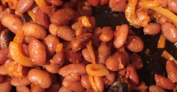 To the onion with tomato paste we transfer the boiled beans until cooked.