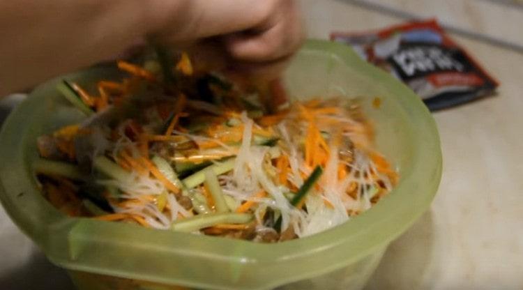 Mélangez bien le funchose avec la viande et les légumes.