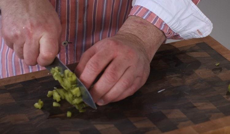 Hachez finement les concombres marinés.