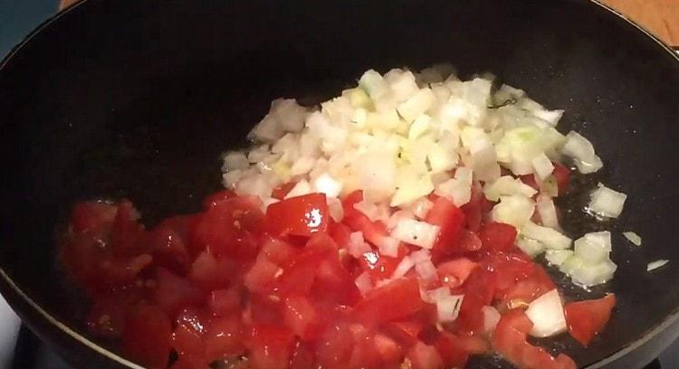 First, put onions and tomatoes in a pan.