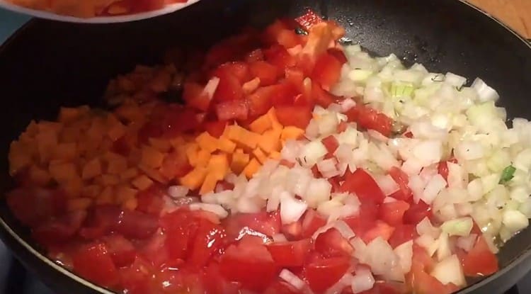 Add pepper and carrot to the onion with tomatoes.