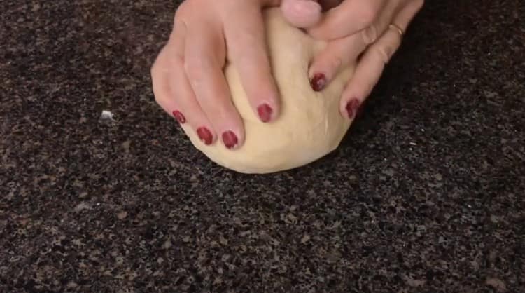 We shift the dough onto the work surface and knead.