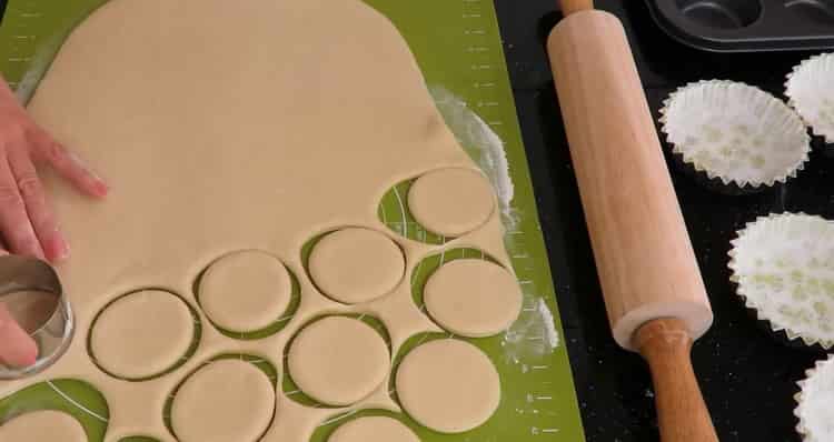 Abaisser la pâte pour faire des petits pains au sucre.