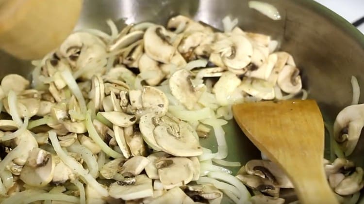 Add mushrooms to the onion in the pan.