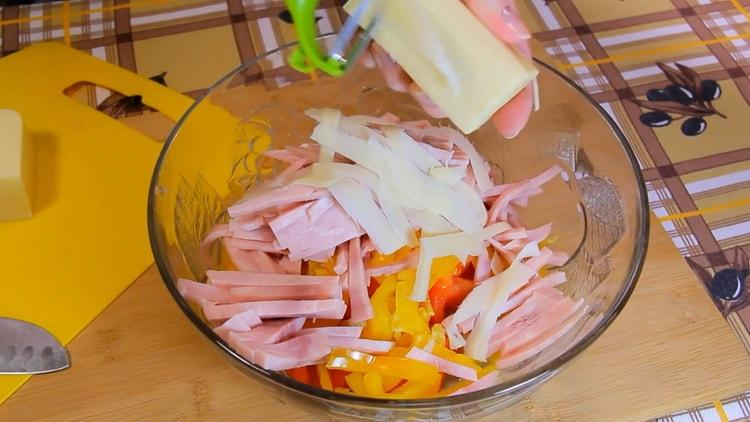 Grate cheese to make a pasta salad