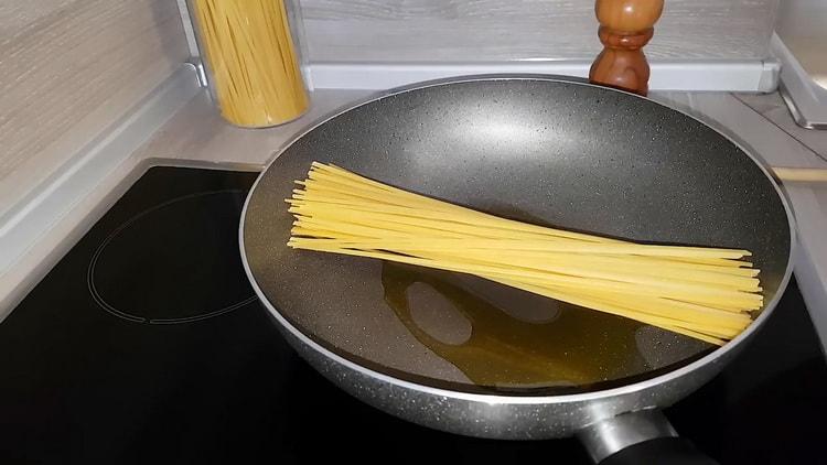 Cooking pasta with chicken in a pan