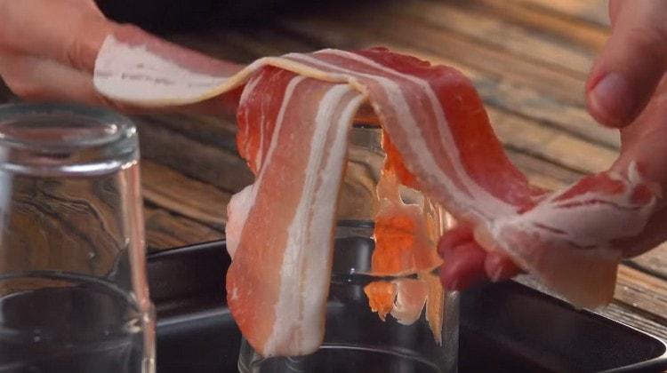 Spread two slices of bacon on a glass, set upside down on a baking sheet.