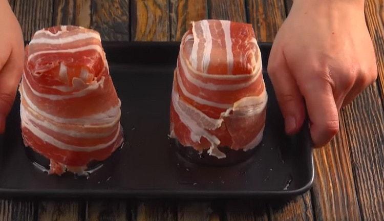 Enveloppez un verre avec deux autres tranches de bacon.