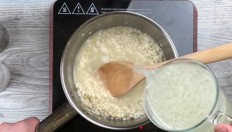 Boil chicken broth to make risotto