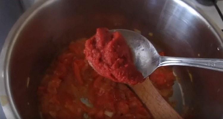 Add tomato paste to the vegetables.
