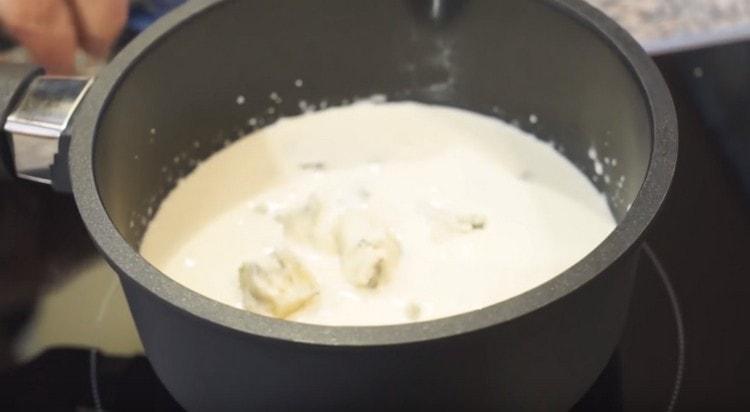Rompa la gorgonzolla en trozos y extiéndala en crema caliente.